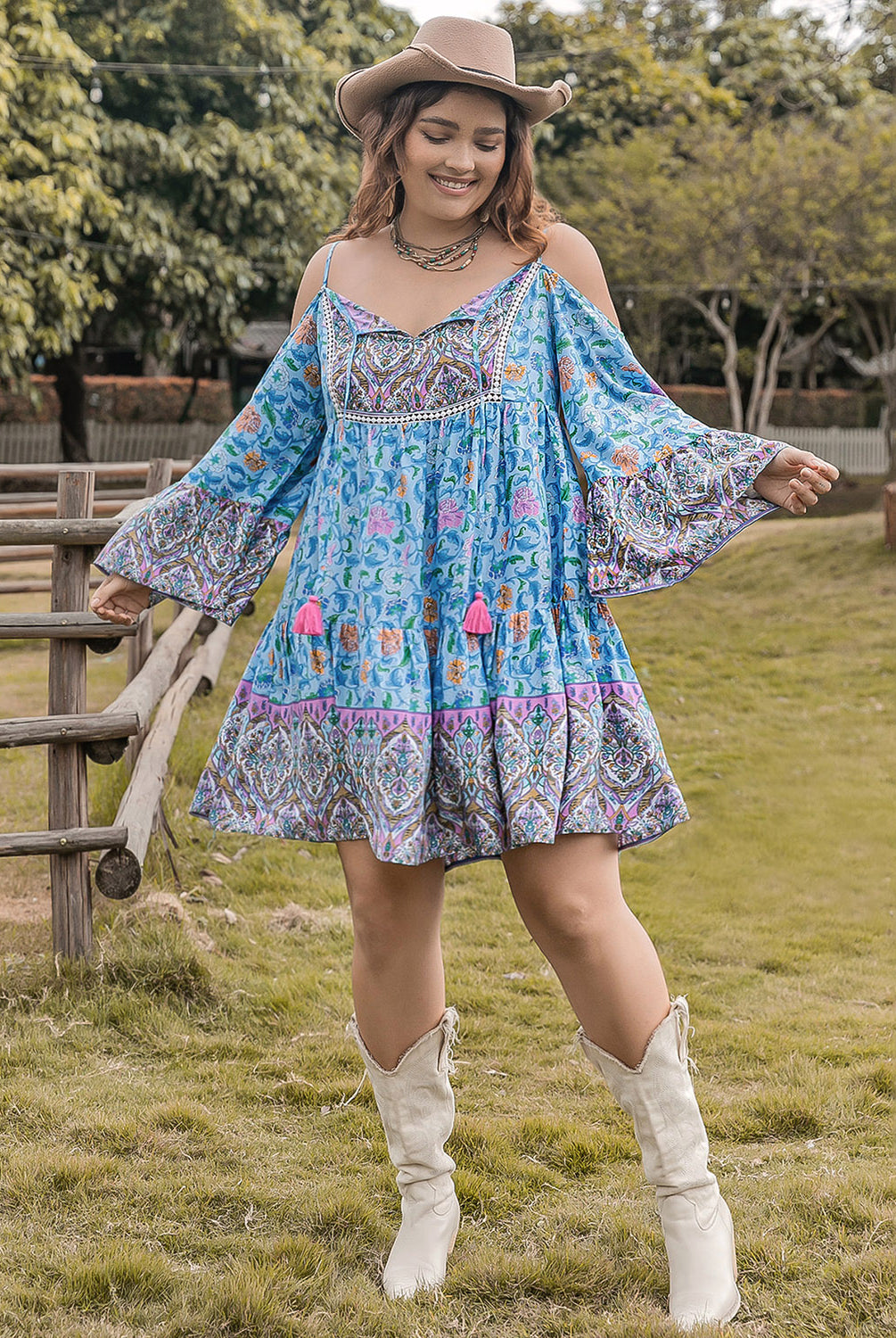 Woman wearing a plus size printed mini dress with long sleeves, featuring coral and sky blue colors, standing outdoors.