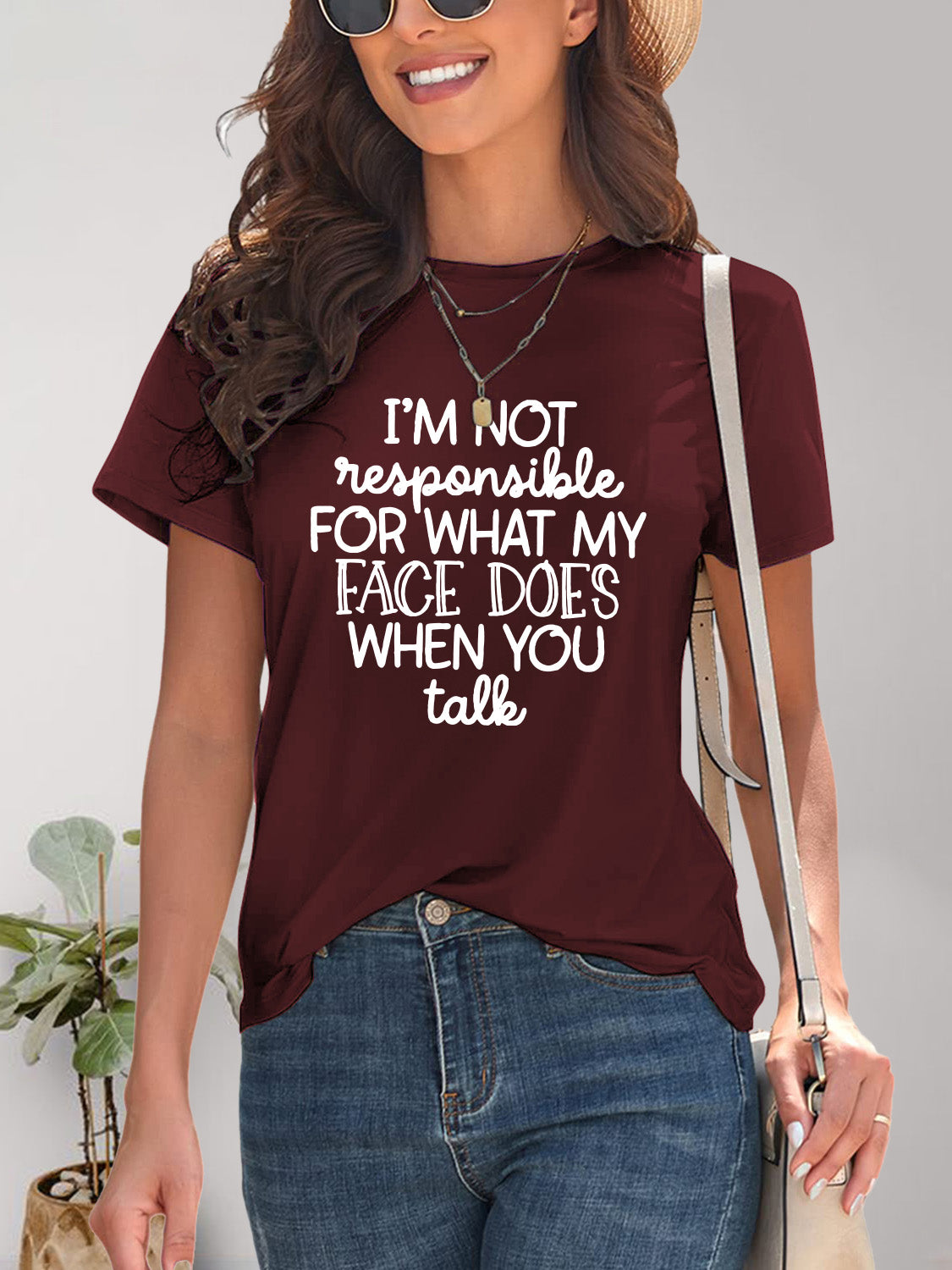  Woman smiling in a green graphic t-shirt with a humorous quote, epitomizing casual cool.