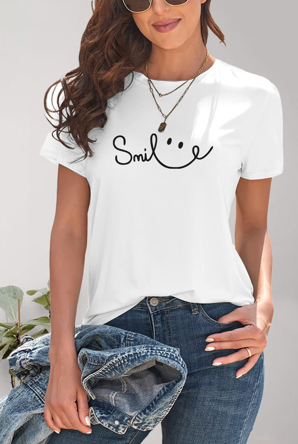 Cheerful woman in a white graphic t-shirt with a 'smile' design, embodying a relaxed and happy vibe.