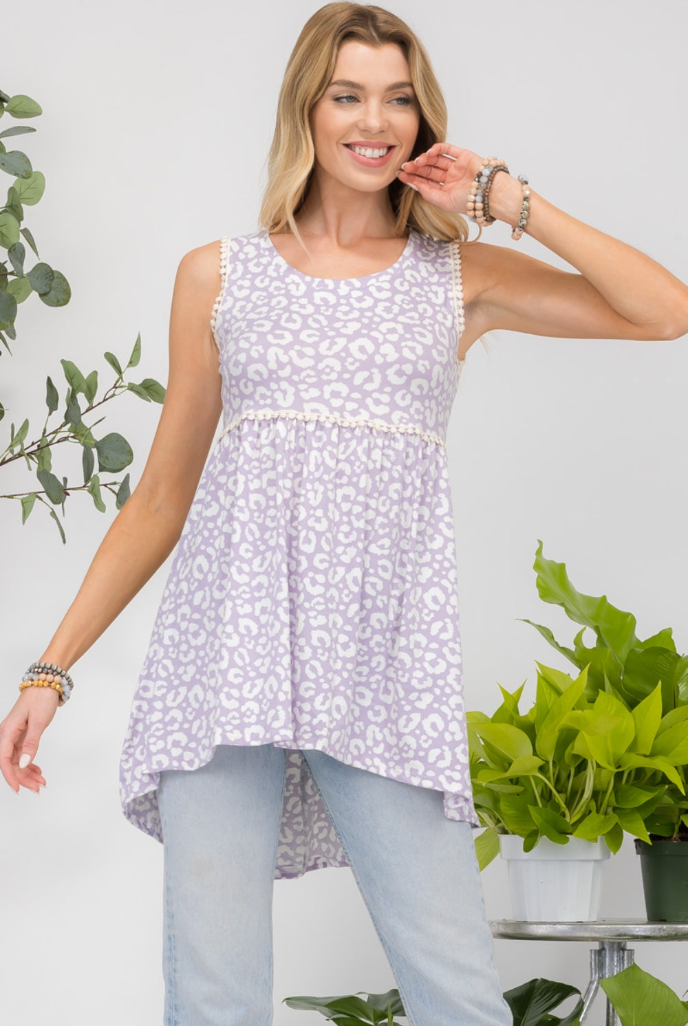 Woman wearing a lilac floral high-low hem tank top, perfect for a casual chic look.