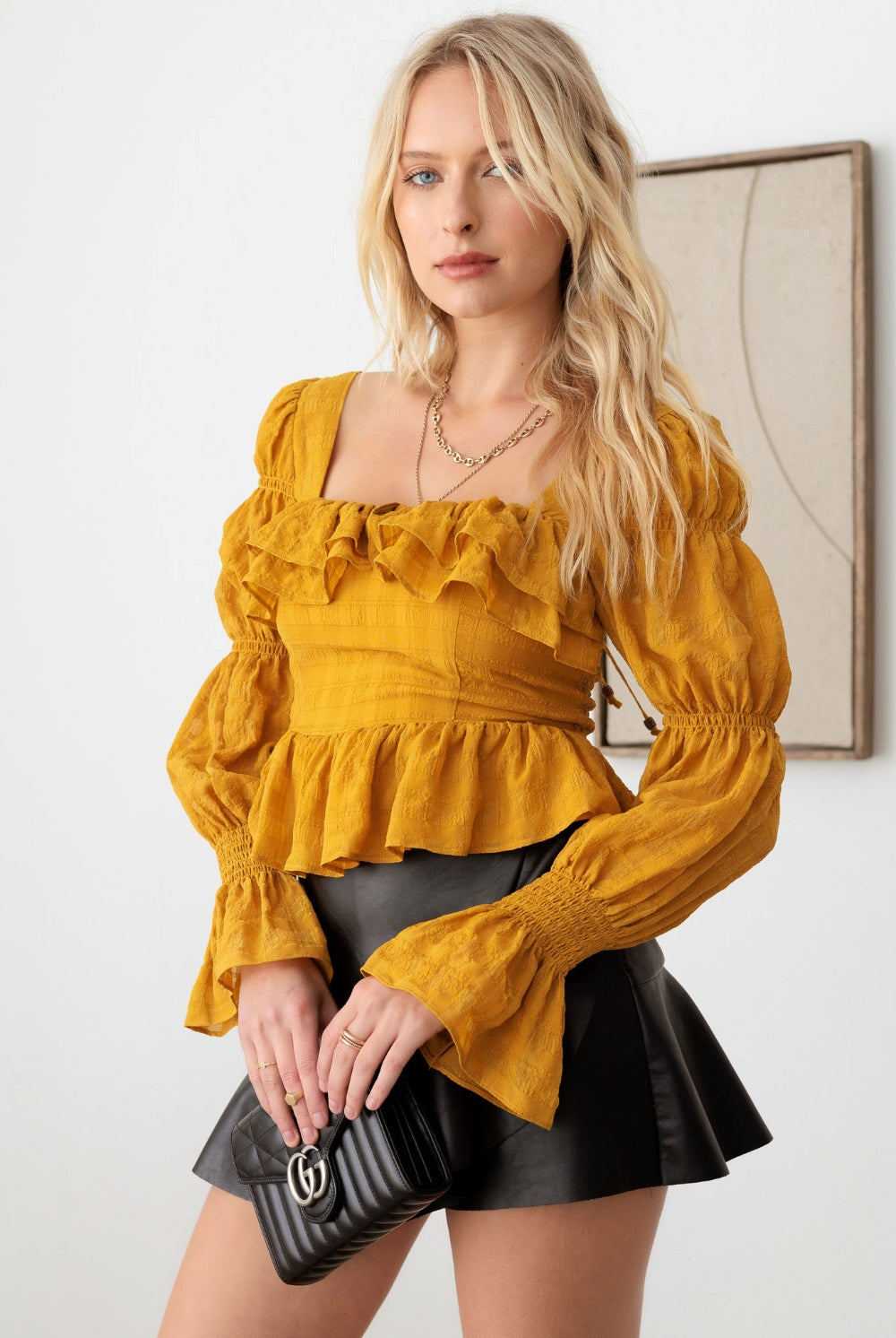 Fashion-forward woman in a mustard boho long sleeve top with delicate ruffle detailing, embodying an effortlessly chic style.