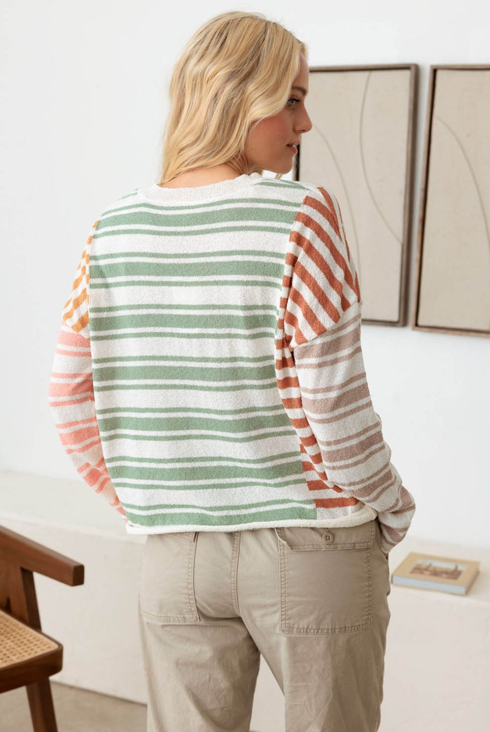 Woman wearing a relaxed multicolor striped long sleeve knit top, epitomizing casual sophistication.