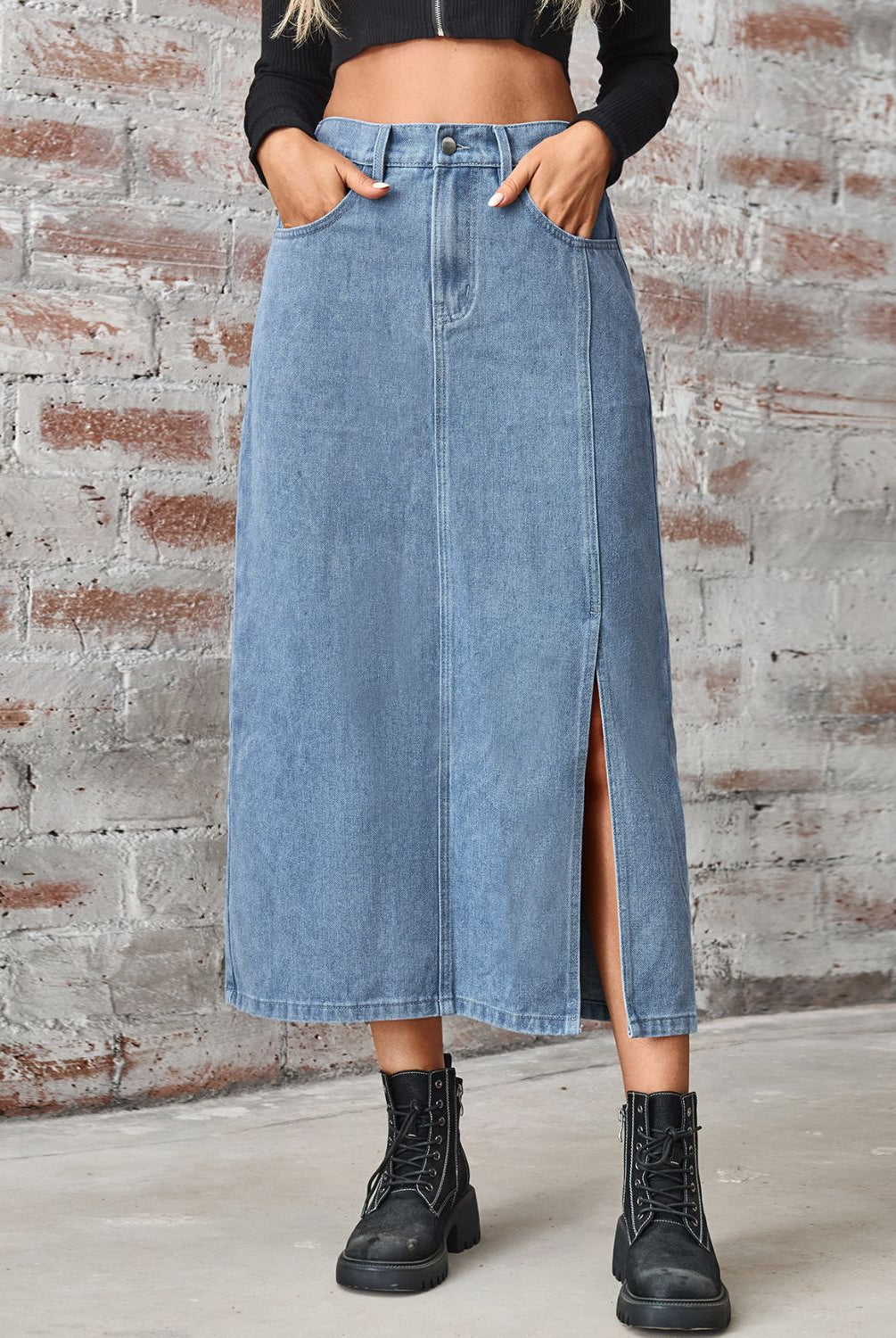 Women's long denim skirt with high waist, slit, and pockets.