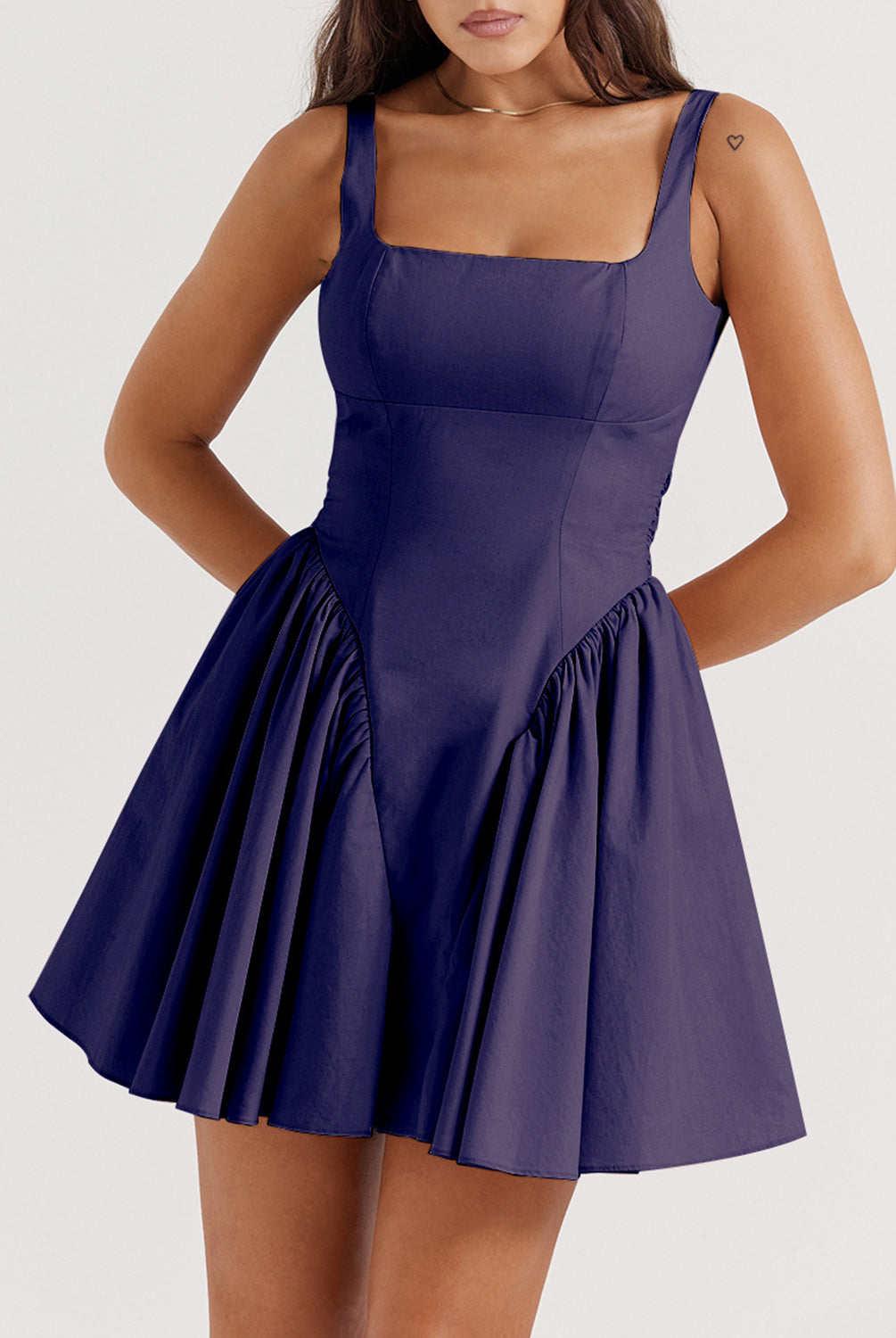 A model exudes elegance in a navy square neck mini dress, showcasing the fitted bodice and flared skirt, making it a perfect choice for a sophisticated night out.