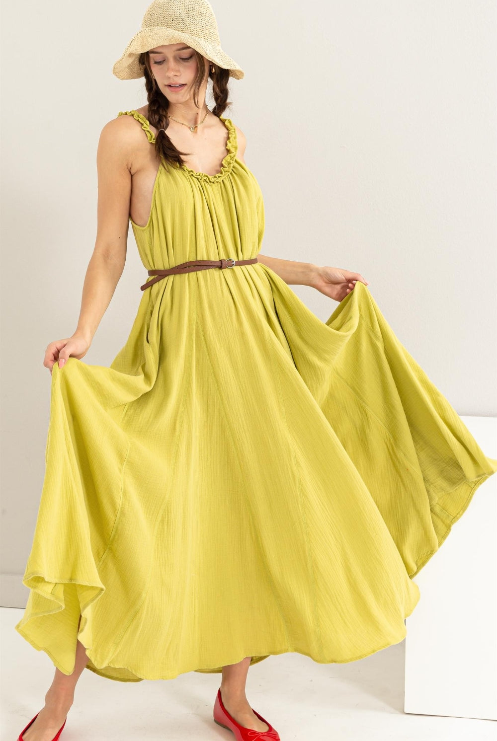 Woman wearing a sleeveless frill maxi dress with a flowy A-line silhouette.
