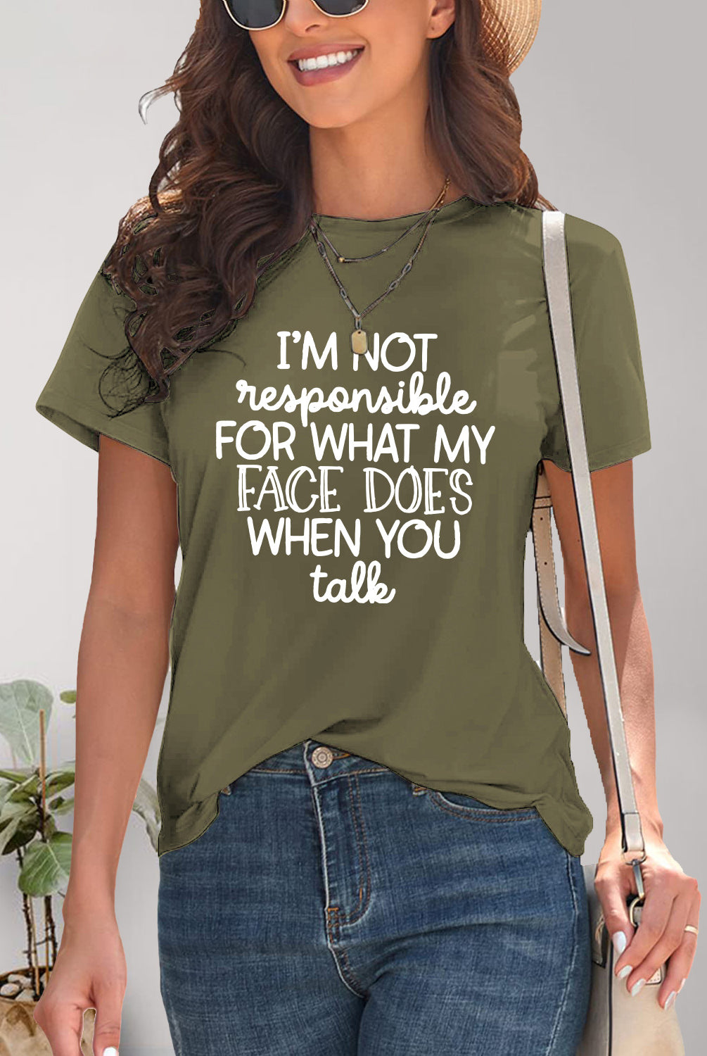  Woman smiling in a green graphic t-shirt with a humorous quote, epitomizing casual cool.