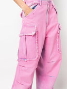  A style-conscious individual sporting eye-catching pink cargo jeans with oversized pockets and fringe detailing, paired effortlessly with a cropped top for a bold, yet practical fashion statement.
