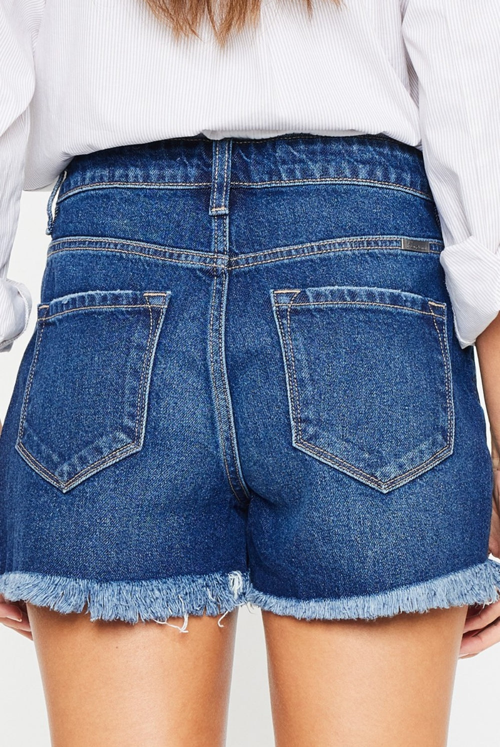 Woman wearing chic blue distressed denim shorts, perfect for a casual summer day.