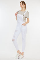 Stylish woman wearing women's distressed overalls, ideal for a relaxed yet fashionable outfit, available at GemThreads Boutique.