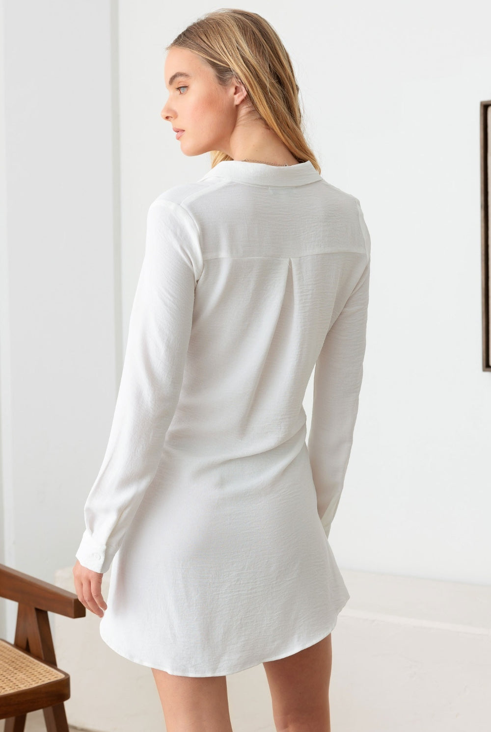 Elegant white mini dress with long sleeves and a tie waist detail, perfect for any occasion.
