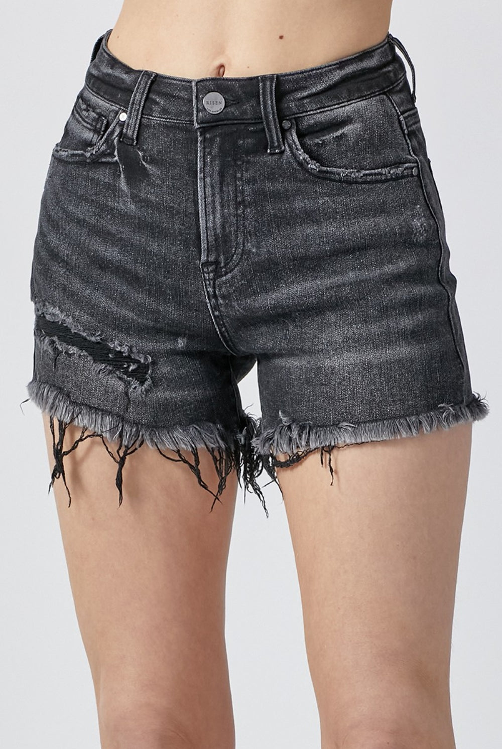 Woman wearing trendy black denim shorts with a frayed hem, perfect for casual summer days.