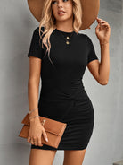 Fashionable woman in a chic black short sleeve dress, accessorized for a stylish day out.