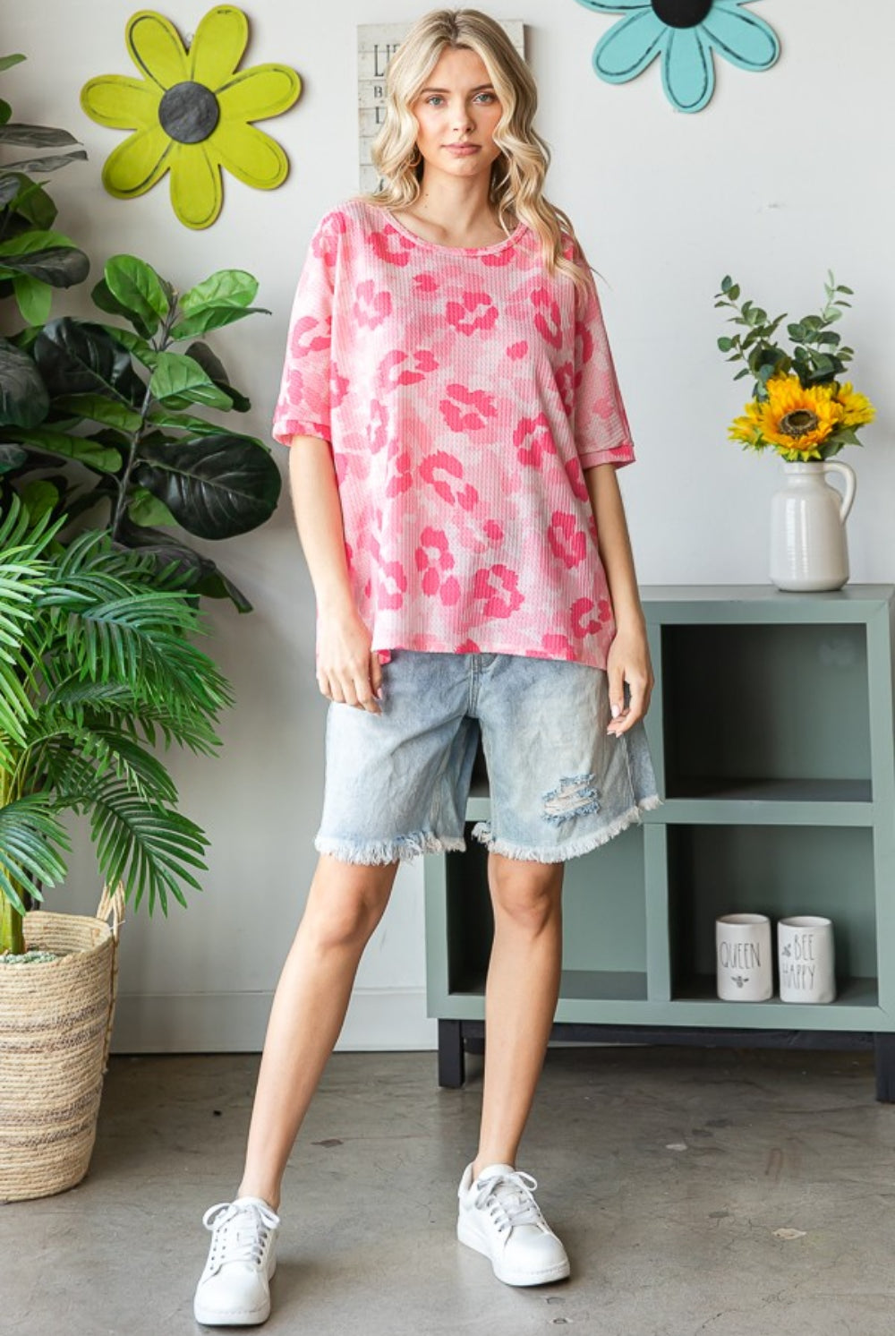 Woman wearing an oversized pink waffle t-shirt with denim shorts, showcasing a relaxed and stylish summer look.