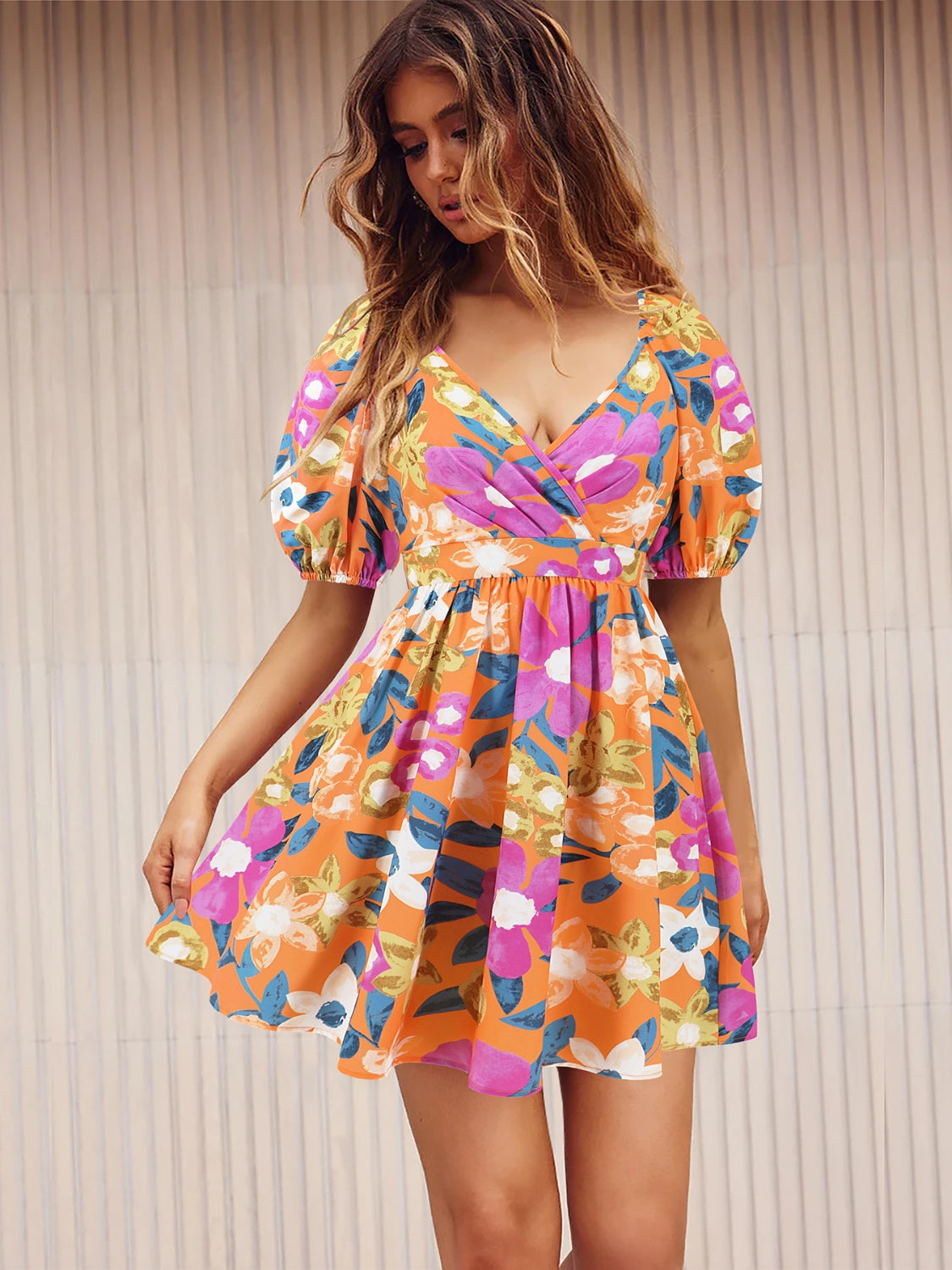Woman wearing a vibrant floral summer surplice dress in tangerine, perfect for casual summer outings.