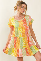 Chic individual in a vibrant patchwork swing dress with summer-inspired color palette and patterns.